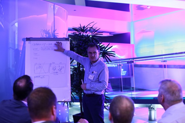 Juan Villamil in front of a white board with colleagues