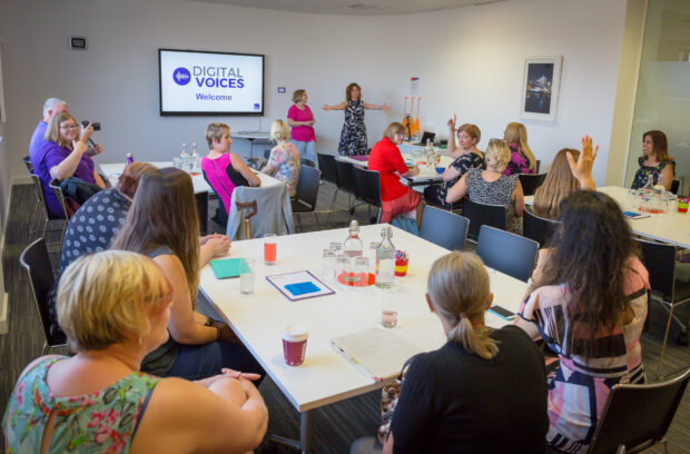 The Digital Voices sat at tables in a meeting room