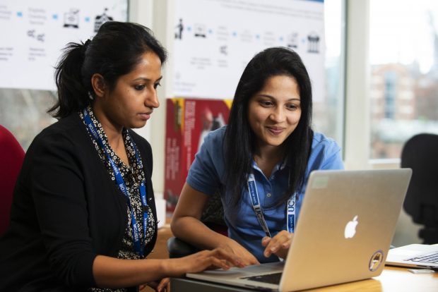 Two female DWP colleagues look at a computer screen