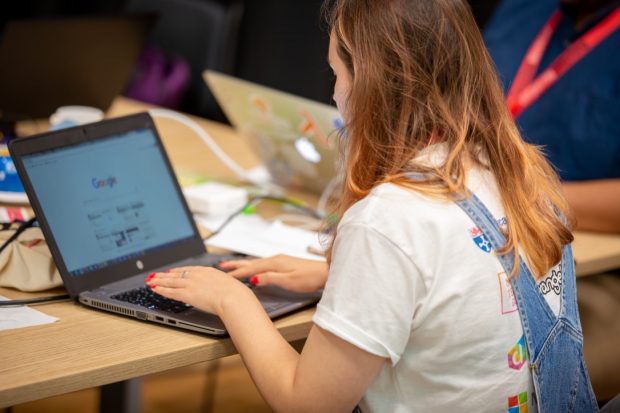 Image of back of a female working on a laptop