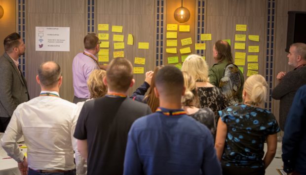 Delegates at the event looking at post it notes on a wall