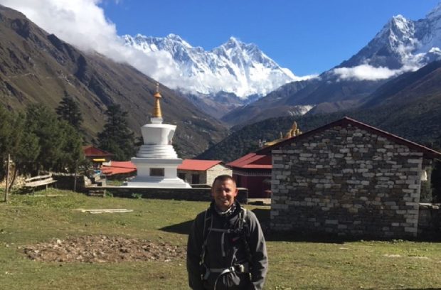 Chris stood in the foreground with mountains behind him 