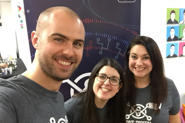 Dan Tanham, Rachel Woods and Nicola Lovesay taking a selfie in front of a hack banner