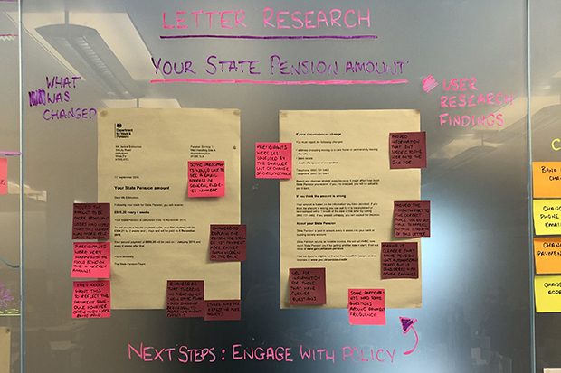 Two example client letters stuck on a glass chanson wall and annoyed with small post-it notes highlighting areas for improvements or changes.