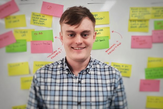 Daniel Pomfret standing in front of a wall of post-it notes