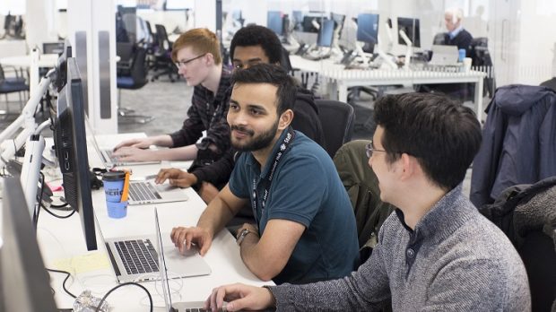 4 male colleauges working at computers together