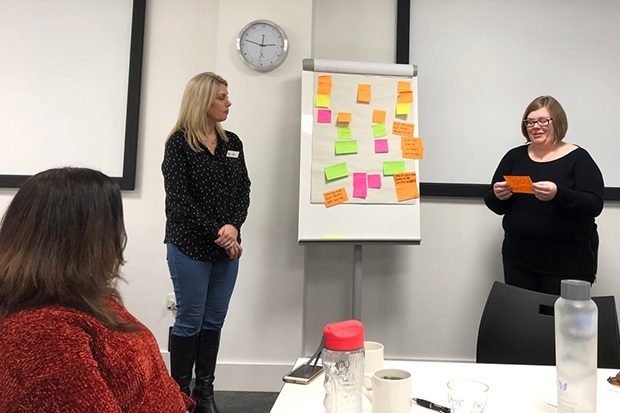 Sue and Debbie during one of the event sessions standing at the front with post it notes