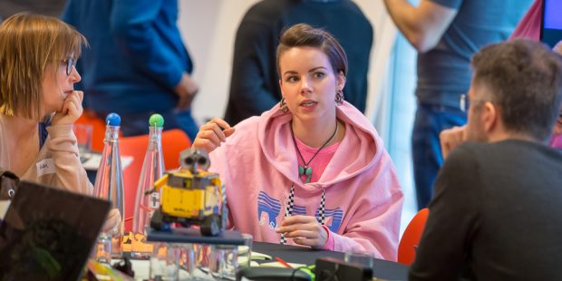 Three people discuss ideas at a table at the Hack The North 3.0 event