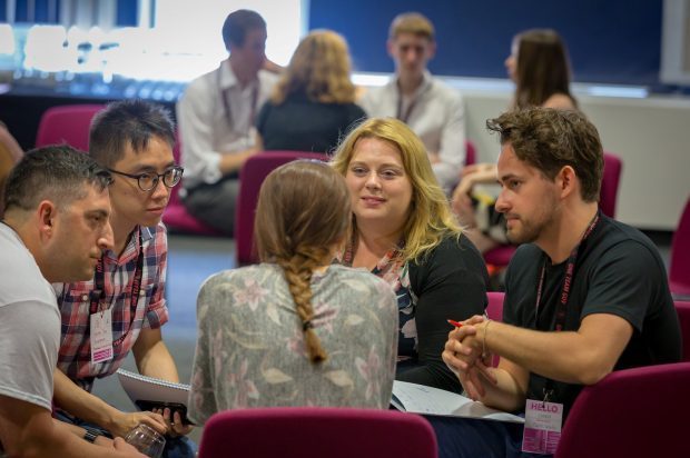 Group discussions at a OneTeamGov event between 5 people including 3 men and 2 women