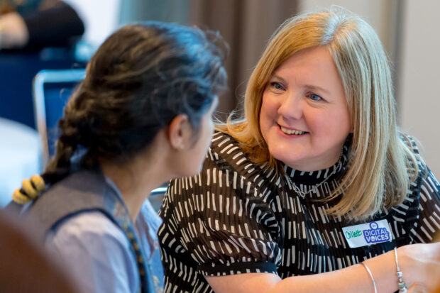 Collett Bellamy chatting with a fellow Digital Voice Rashmi Hangalur at a table