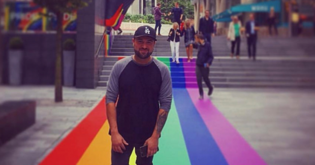 Taran standing on a rainbow coloured carpet