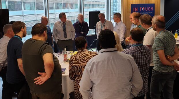 Colleagues gathered around a table sharing ideas at the SRE meet-up