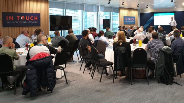 People sat at conference tables listening toa presentation at the SER meet-up