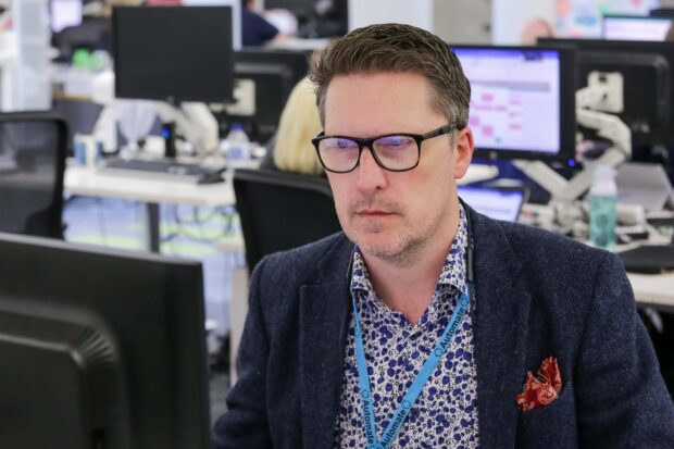 Sean Luke looks at a computer screen in an office