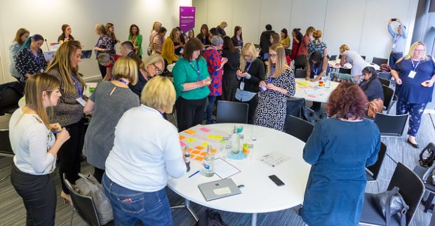 Female colleagues collaborating at Women in Digital, writing on Post it Notes