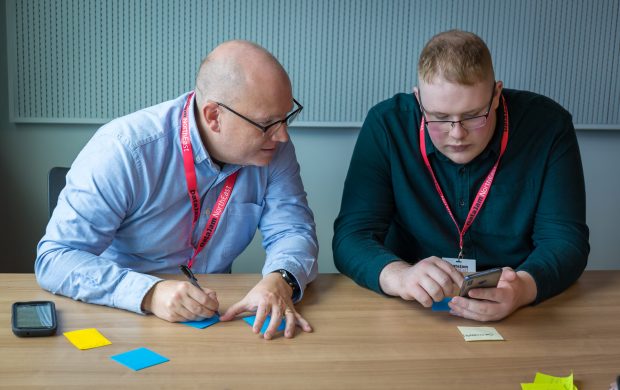 Mark and another DataJam attendee capturing ideas on post-its and mobile phone