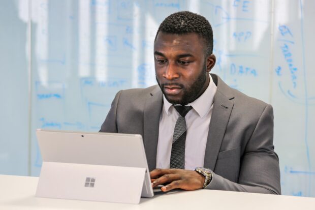 Mbeh Tanij working at a desk on a laptop