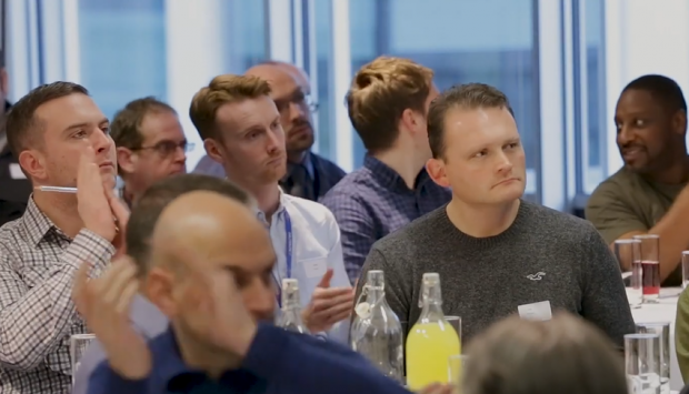 Photo of attendees at the event watching one of the speakers