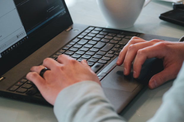 Person pressing keys on a laptop