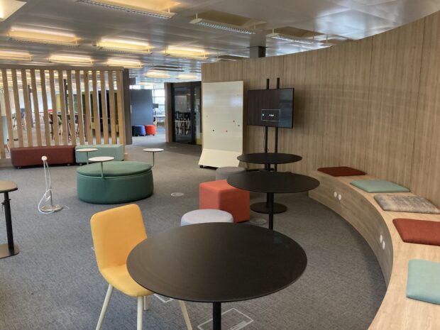 Test and learn space in Newcaslt hub showing a bright and airy space with various seating options, a whiteboard and a television screen