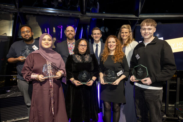 A mixed group of smartly dressed people holding awards